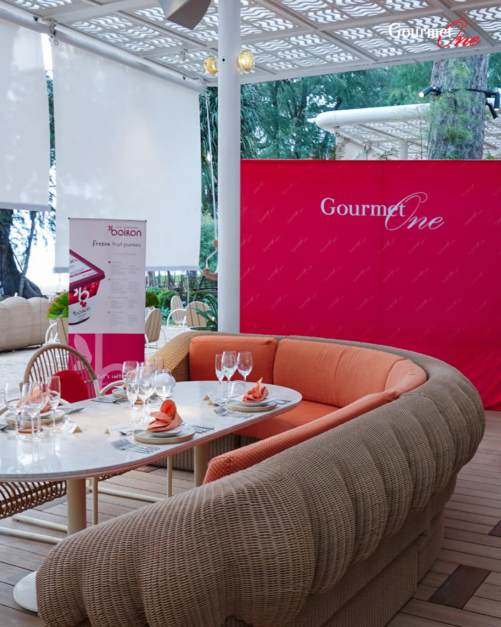 An elegant curved banquette and table prepared for the Gourmet One dinner.