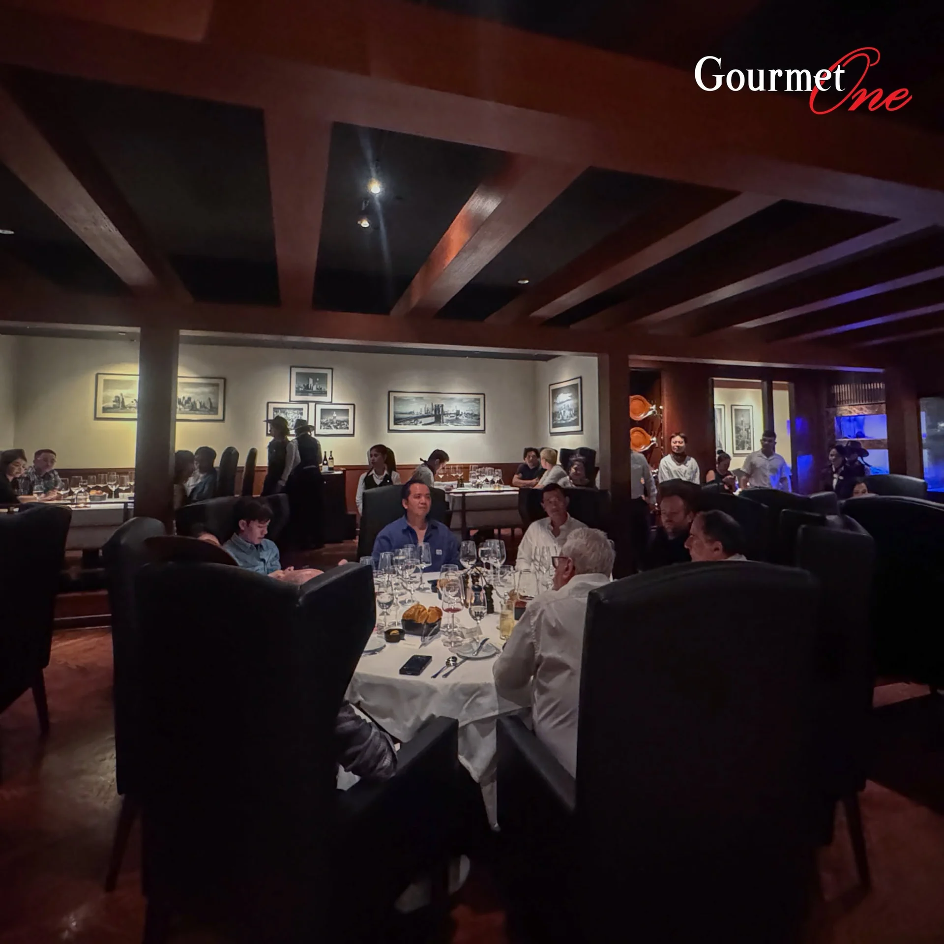 A wide view of guests dining in the softly lit restaurant.